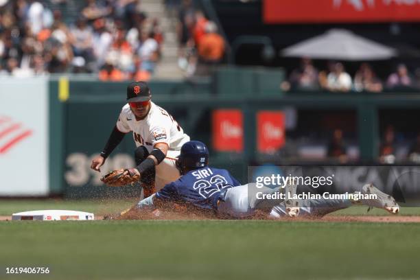 Jose Siri of the Tampa Bay Rays is tagged out by Thairo Estrada of the San Francisco Giants at second base after hitting a single in the fourth...