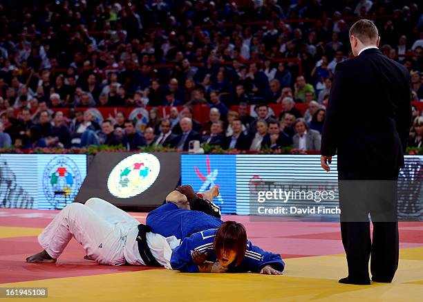 Carefully watched by the referee, Eun Gyeong Kim of South Korea , holds Emile Andeol of France on her back by trapping her head and arm with her...