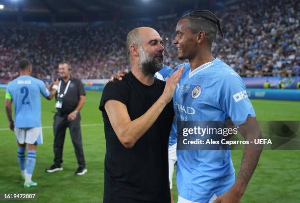 Pep Guardiola, Manager of Manchester City, and Manuel Akanji of Manchester City celebrate following the team's victory in the penalty shoot out...