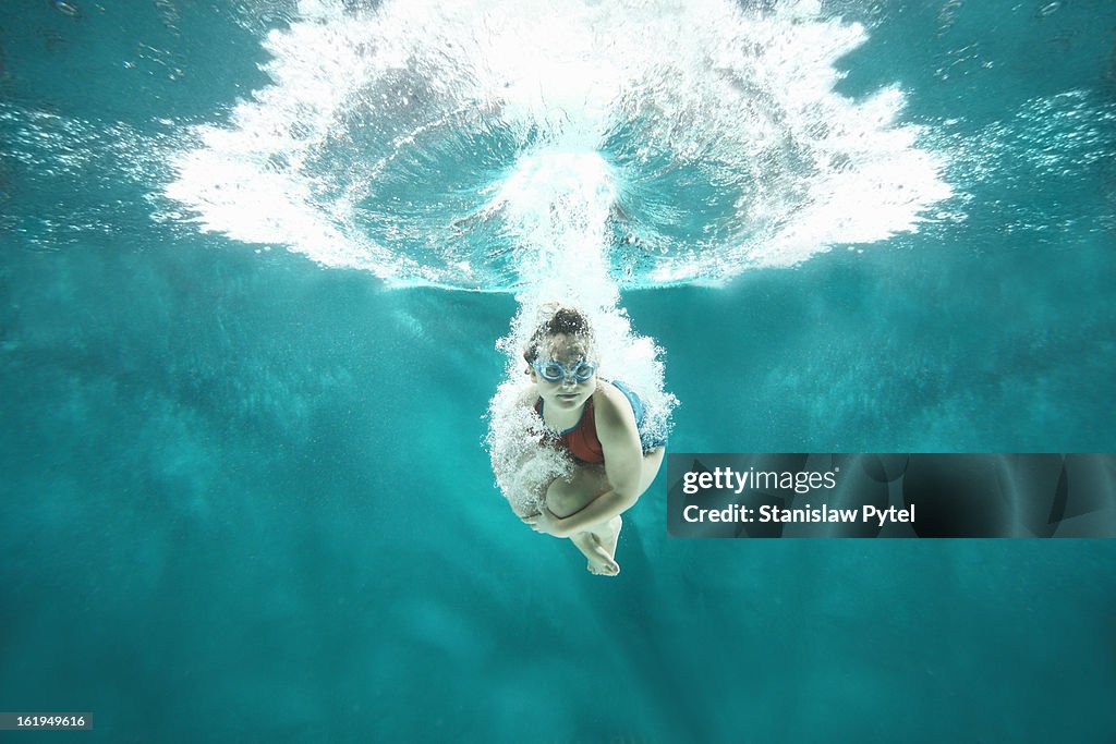 Small girl jumping into the water- underwater view