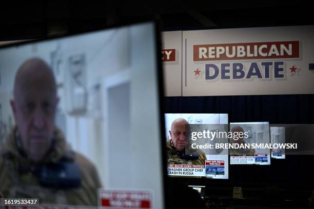 Screens shows images of Yevgeny Prigozhin, the head of the Wagner group, ahead of the first Republican Presidential primary debate at the Fiserv...