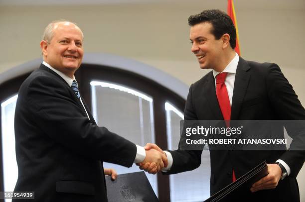 Serbia's Foreign Minister Ivan Mrkic shakes hands with his Macedonian counterpart Nikola Poposki after their meeting in Skopje on February 18, 2013....