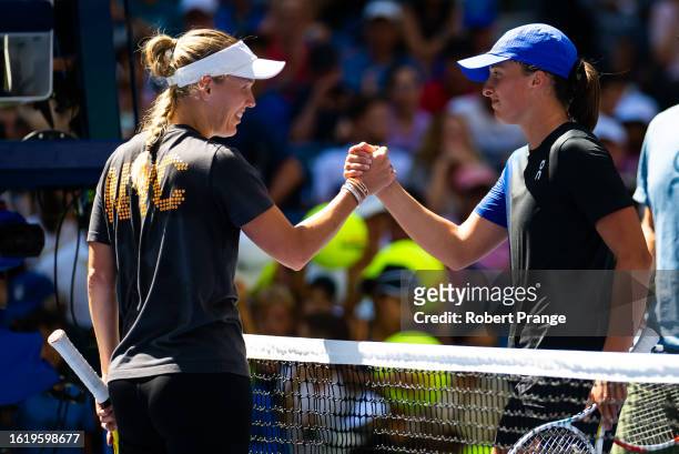 Caroline Wozniacki of Denmark and Iga Swiatek of Poland shake hands at the net after practice ahead of the US Open at USTA Billie Jean King National...