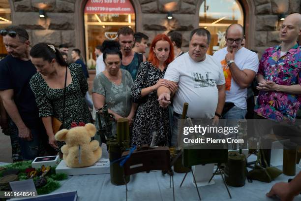 People look at Russian mines and a Russian booby trap in a teddy bear on August 23, 2023 in Kyiv, Ukraine. August 23 marks the Day of the Ukrainian...