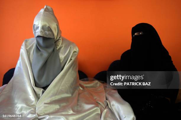 Palestinian bride Aida al-Qaddumi sits with her friend and witness as she waits for her groom at a beauty salon in Gaza City on January 22, 2009....