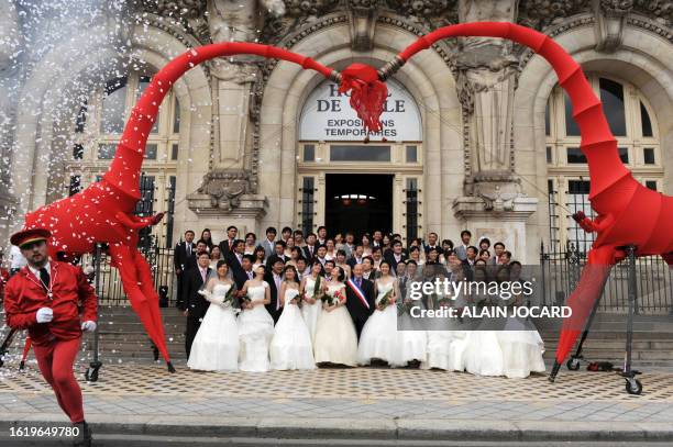 Trente et un couples chinois originaires de la ville de Tianjin et récemment mariés dans leur pays, posent le 07 mai 2009 devant le mairie de Tours,...