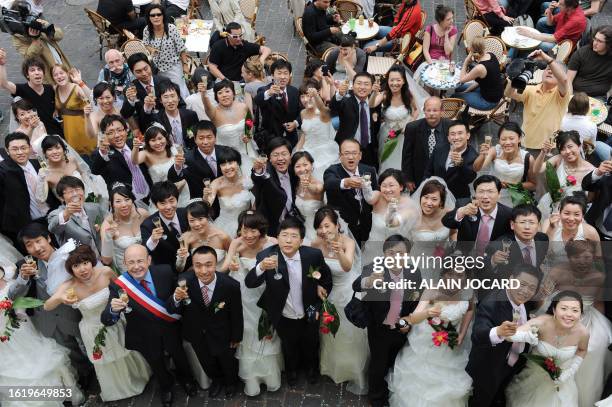 Trente et un couples chinois originaires de la ville de Tianjin et récemment mariés dans leur pays, trinquent le 07 mai 2009 à Tours en compagnie du...