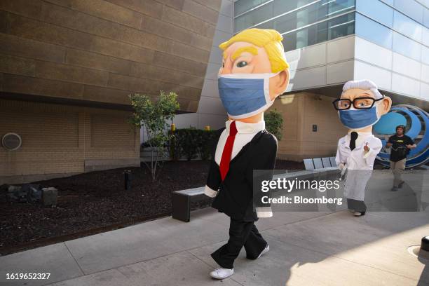 Demonstrators dressed as former US President Donald Trump, center, and Anthony Fauci, former director of the National Institute of Allergy and...