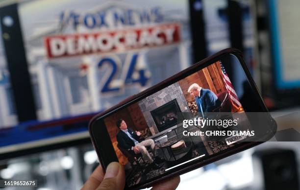 This illustration photo shows a preview of Tucker Carlson's interview of former US President Donald Trump scheduled to air on X on the same night of...