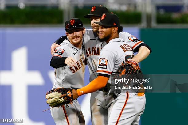 Outfielders Wade Meckler, Austin Slater and Luis Matos of the San Francisco Giants embrace after defeating the Philadelphia Phillies 8-6 in a 10...