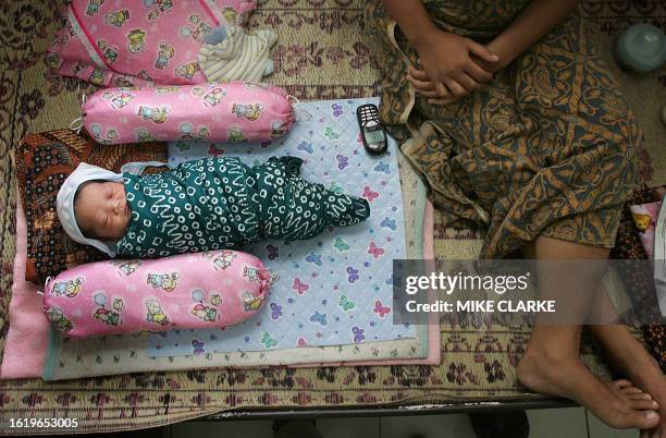 Three-day-old baby lies in a hospital bed in Yogyakarta, 01 June 2006, after his mother survived the 27 May 6.3 magnitude earthquake by standing in...