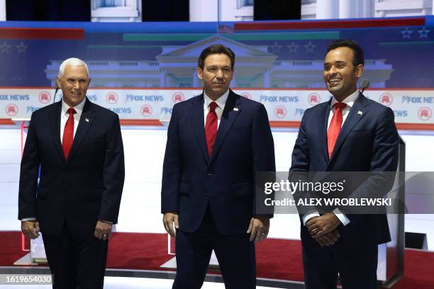 Former US Vice President Mike Pence, Florida Governor Ron DeSantis and entrepreneur and author Vivek Ramaswamy arrive on stage for the first...