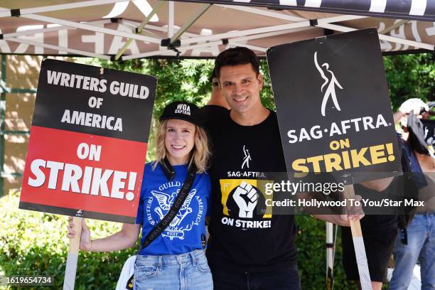 Valerie Brandy and Kash Hovey walk the picket line in support of the SAG-AFTRA and WGA strike on August 23, 2023 at Warner Brothers Studios in...