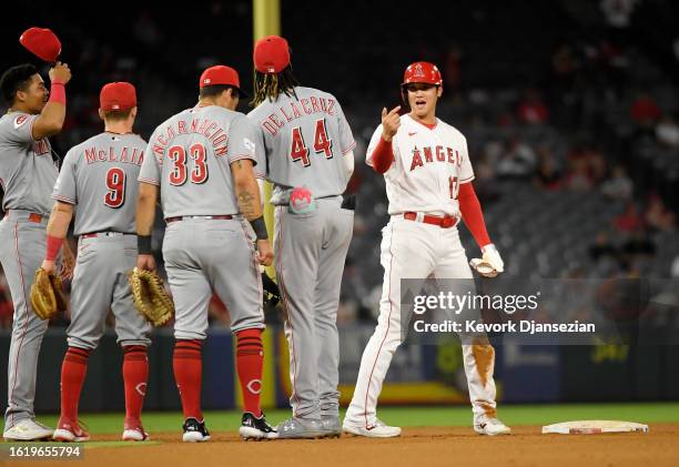 Designated hitter Shohei Ohtani of the Los Angeles Angels is greeted by Cincinnati Reds infielders Noelvi Marte, Matt McLain, Christian...