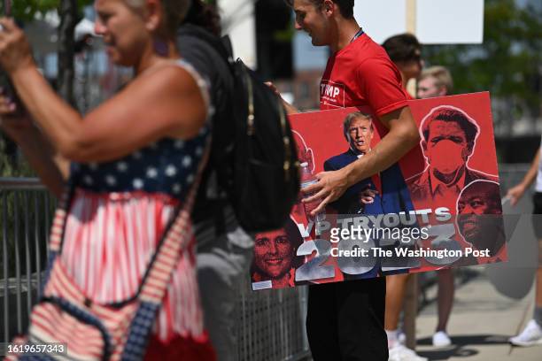 Supporter for Former President and presidential candidate Donald Trump holds a sign outside Fiserv Forum Tuesday, August 23, 2023 in Milwaukee,...