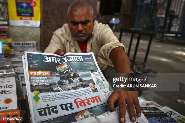 Vendor arranges daily hindi newspapers with front pages reporting on successful landing of ISRO's Chandrayaan-3 spacecraft on the south pole of the...