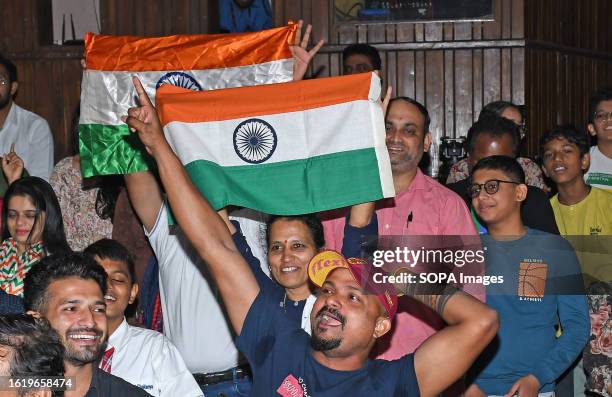 People holding Indian flags celebrate while watching the live streaming at Nehru Science Center in Mumbai about the soft landing of Chandrayaan-3 on...