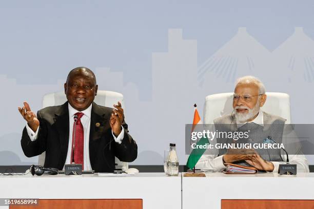 South African President Cyril Ramaphosa and Prime Minister of India Narendra Modi gesture as they attend the 2023 BRICS Summit at the Sandton...