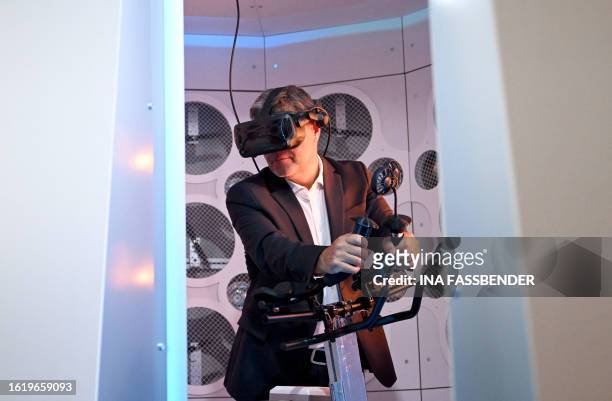 German Minister of Economics and Climate Protection Robert Habeck tries out the environment simulation pod DIVE+, a novel simulator that combines...
