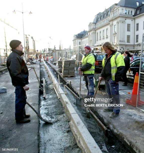 Three building workers Claes Helenius, Robert Carlsson and Peteri Joronen, observe three minutes of silence for the victims of the south Asian...