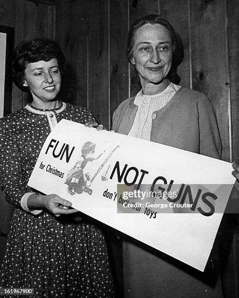 Denver members of Women's League for International Peace and Freedom display sing of protest, photo left. They're Mrs. John Gilmore, left, and Mrs....