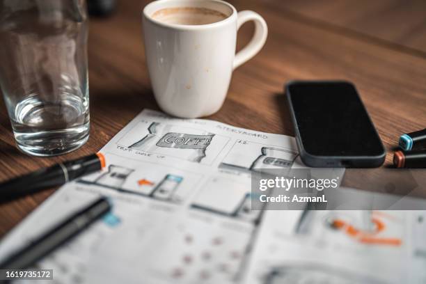 storyboard editors table; coffee, colored pencils and a smartphone - roteiro imagens e fotografias de stock