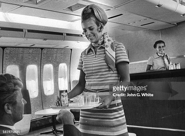Jack Gregory Of Los Angeles Receives Drink In Polynesian Pub; Providing service aboard Continental Airlines' 747 is Maureen Guth, serving, and Joy...