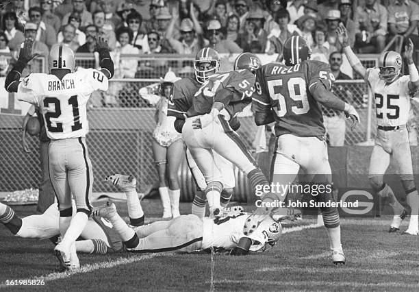 Football - Denver Broncos ; Oakland's Fred Biletnikoff and Cliff Branch signal touchdown as teammate Clarence Davis hits into the end zone for score...