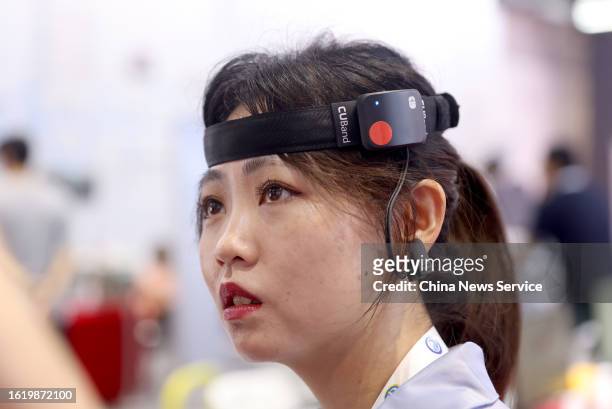Visitor tries brain-computer interface for attention training during 2023 World Robot Conference at Beijing Etrong International Exhibition &...