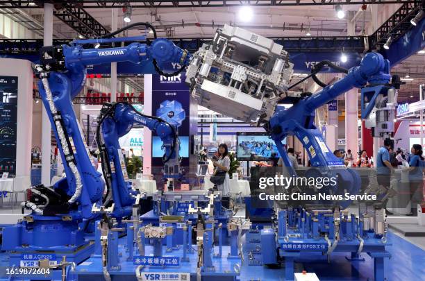 Yaskawa robots work on the production line of new energy battery boxes during 2023 World Robot Conference at Beijing Etrong International Exhibition...