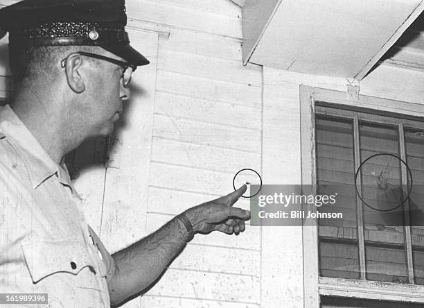 Policeman Points Out Bullet Holes in Witness' House; Patrolman Frank Antonio shows holes in wall and window of home of Hal W. Eastman, 2125 S....