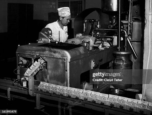 Half-pint containers of milk roll off the assembly line at the Garden Farm Dairy, E. 60th Ave. And Albion St., as John Peters of Derby, operator,...