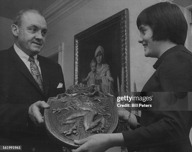 Dr. Frank McGlone shows his daughter, Maureen, ninth grade student at St. Mary's Academy, a coat-of-arms similar to the one in "Camelot." The benefit...
