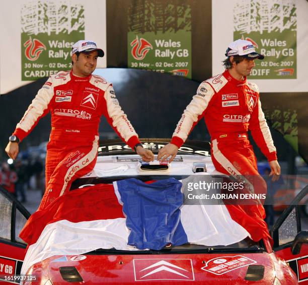 Citroen driver Sebastien Loeb, of France and his co-driver Monaco's Daniel Elena celebrate on the podium after securing The World Rally Championship...