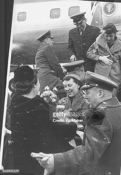 Maj. Gen. Eugene P. Mussett , Lowry Air Base commandant, ushers his wife and Mrs. Mamie Eisenhower together for presentation of a bouquet of pink tea...