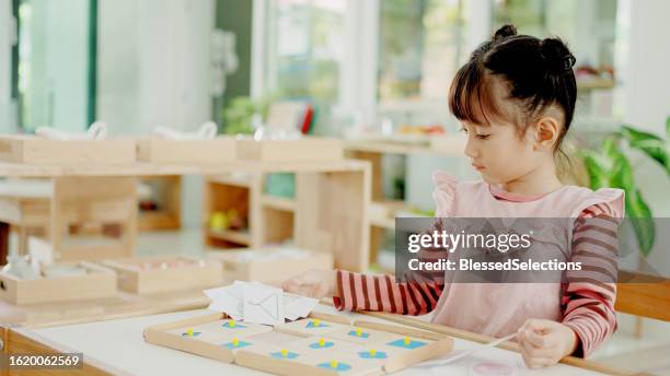 preschool mixed girl learning about shape using geometric inset, - qualifying school stock pictures, royalty-free photos & images