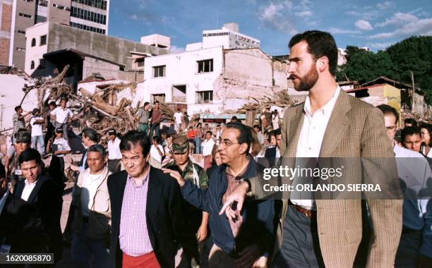 The Spanish Prince Felipe surveys the damage 13 November in the downtown area of Tegucigalpa, Honduras after the Choluteca river crested and flooded...