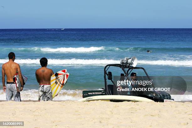 Surfers look out to sea at Bondi Beach in Sydney, 02 April 2007, after being given a warning by the Bondi lifesavers that it may be dangerous to...