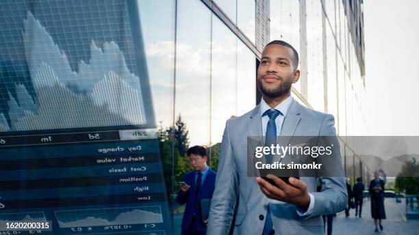 man using digital tablet - black suit stock pictures, royalty-free photos & images