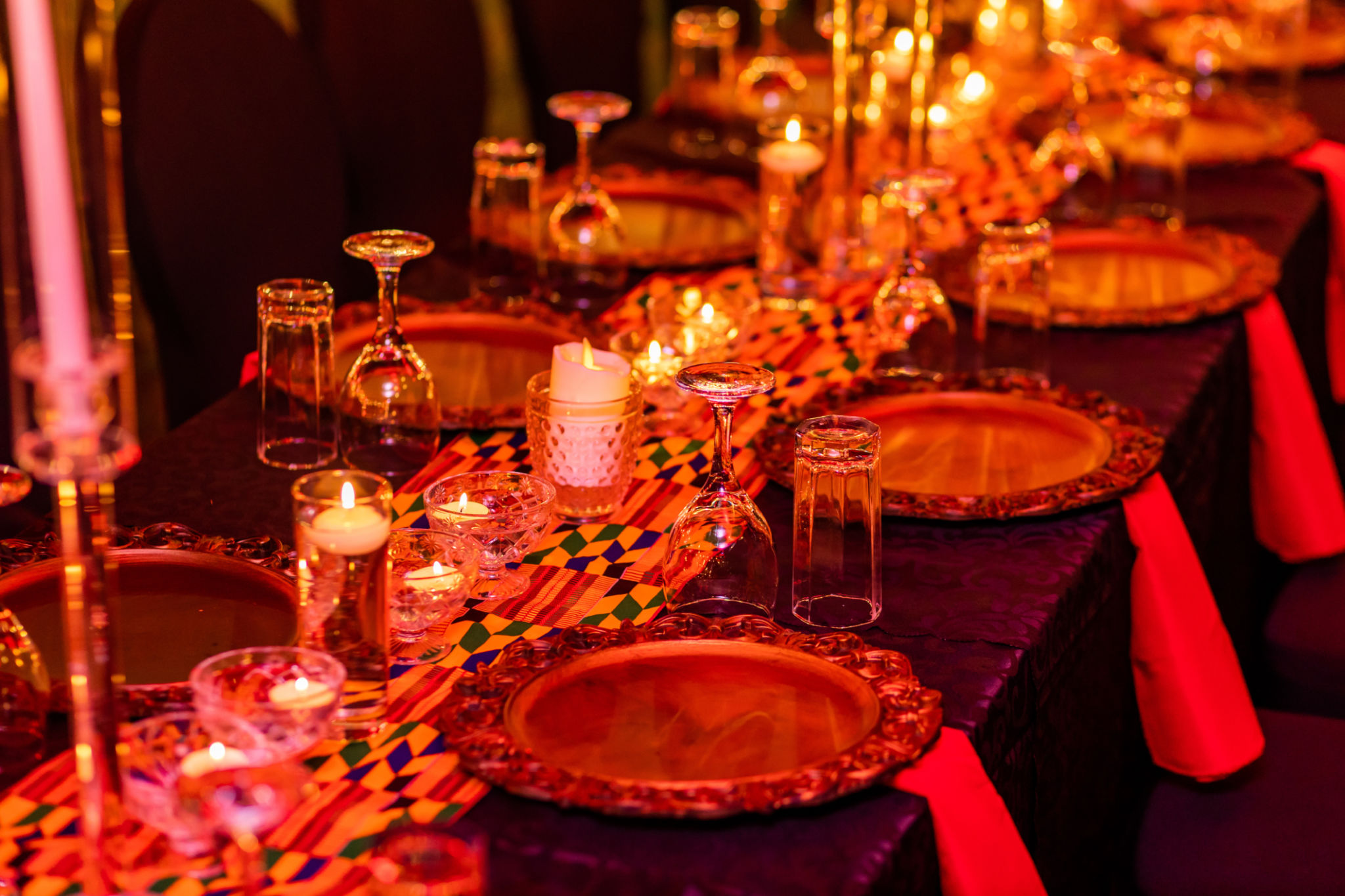 Red and Gold Themed Candlelit Evening Dinner Setup with Wine Glasses, Napkins and Plates. Red and Gold Themed Candlelit Evening Dinner Setup with Wine Glasses, Napkins and Plates.
