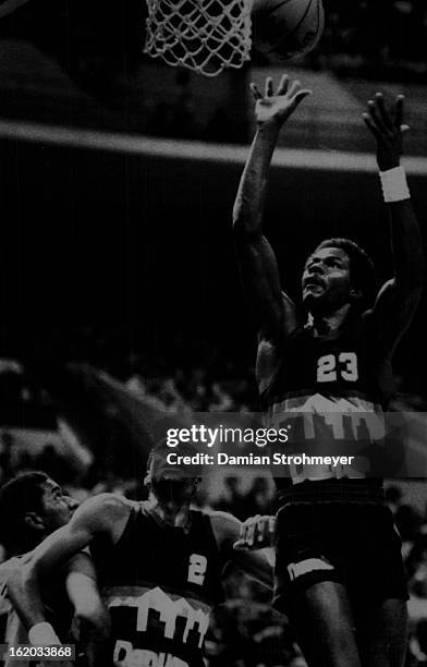 Special Transmission to The Denver Post - T.R. Dunn of the Nuggets lofts a shot to the basket while Alex English of the Nuggets and George Gervin of...