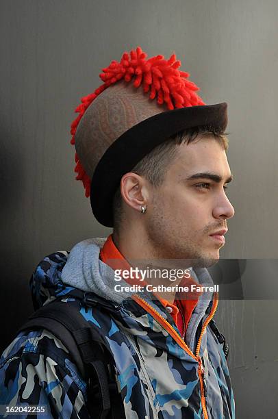 Milliner Jordan Bowen wearing his own punk inspired paisley printed heritage style hat with red cockscomb quiff at London Fashion Week Fall/Winter...