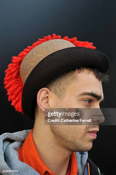 Milliner Jordan Bowen wearing his own punk inspired paisley printed heritage style hat with red cockscomb quiff at London Fashion Week Fall/Winter...