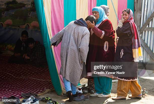 Kashmiri Muslim women relatives of 14-year-old Ghalib Afzal Guru, the son of executed Kashmiri separatist Afzal Guru, weep and console him at his...