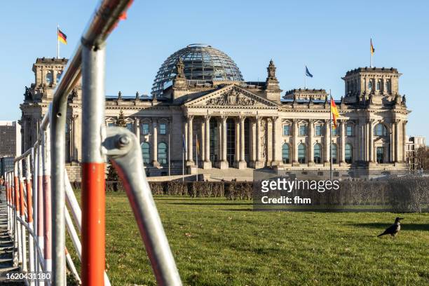 reichstag building with mobile police fence (german parliament building) - berlin, germany - politiek stock-fotos und bilder