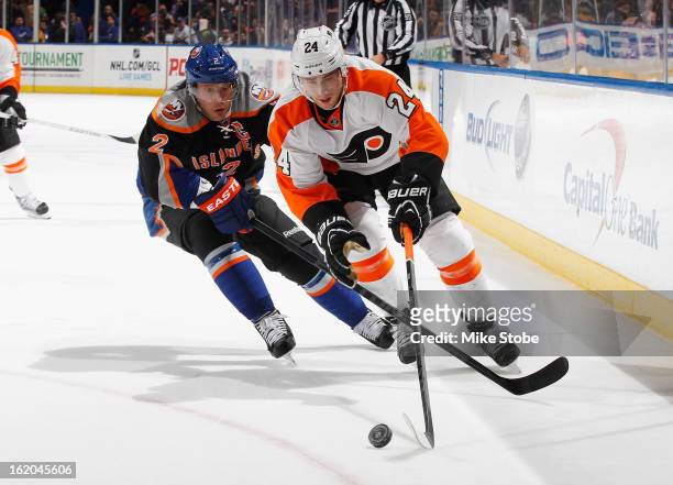Matt Read of the Philadelphia Flyers controls the puck in front of Mark Streit of the New York Islanders at Nassau Veterans Memorial Coliseum on...
