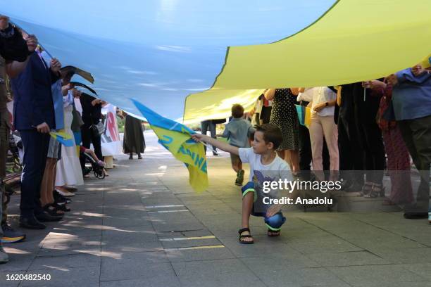 Child waves Ukrainian flag as Ukrainians, along with ambassadors and international representatives, gather to attend march held to celebrate...