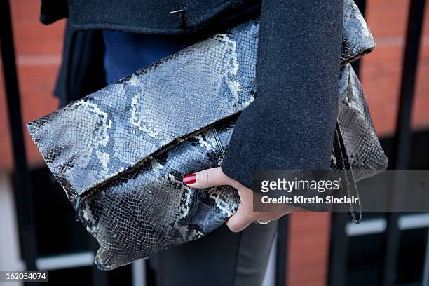 Market Editor for ELLE Magazine carries a vintage snake skin clutch on day 3 of London Womens Fashion Week Autumn/Winter 2013 on February 17, 2013 in...