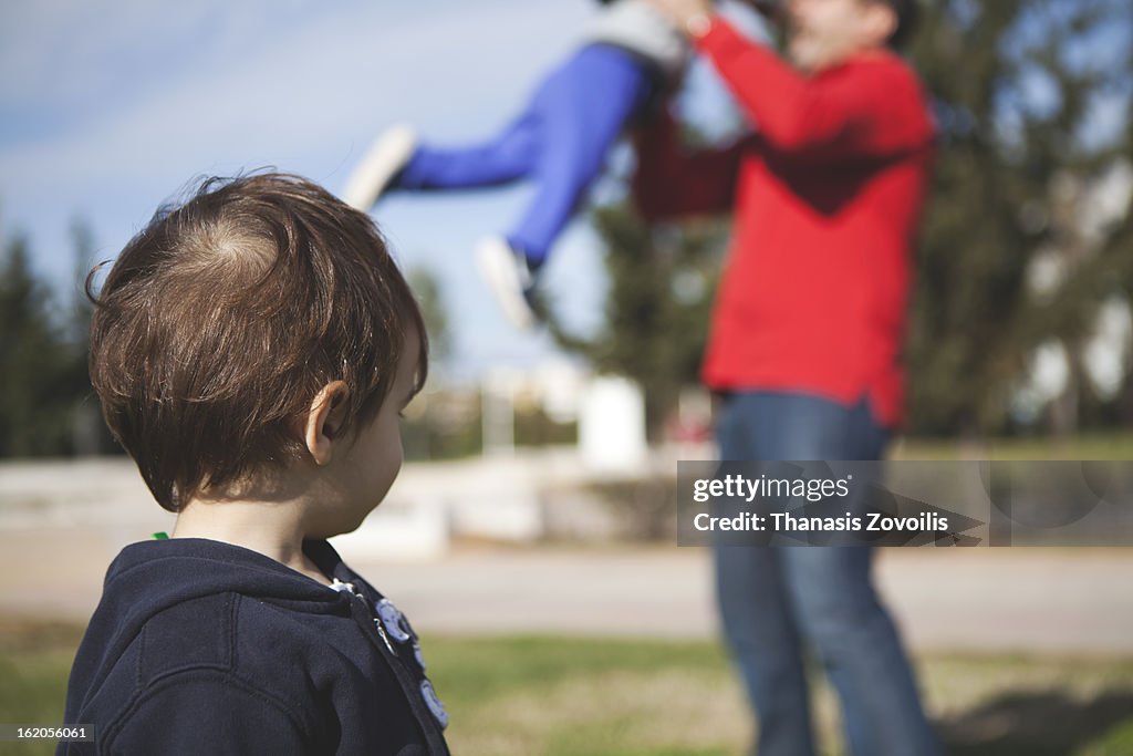 Small boy looking a father playing with his kid