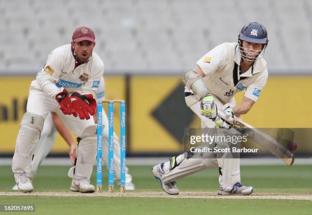 Chris Rogers of Victoria bats as wicketkeeper Chris Hartley of the Bulls looks on during day two of the Sheffield Shield match between the Victorian...